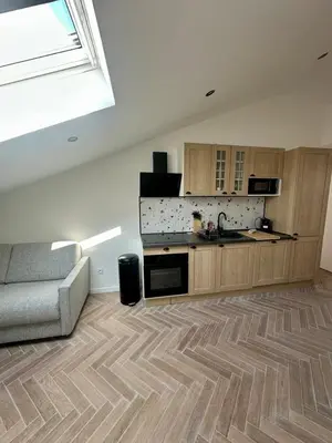 a living room with a couch and a kitchen at GIOFFREDO SUITE in Nice