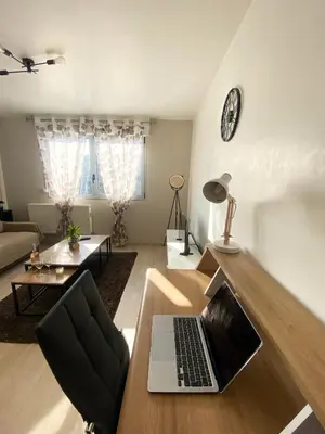 a living room with a laptop on a wooden table at Bel Appartement 2 pièces - 10min de la mer in Nice