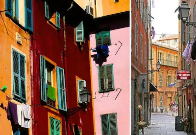 a narrow alley with colorful buildings and windows at Nestor&Jeeves - VIEUX NICE SUITE - Studio - Centre in Nice