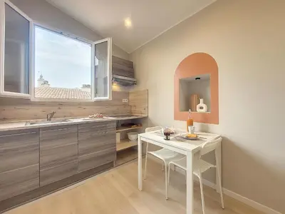 a kitchen with a table and a sink and a window at Nestor&Jeeves - VIEUX NICE SUITE - Studio - Centre in Nice