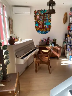a living room with a piano and a chair at Maison de ville avec jardin in Nice