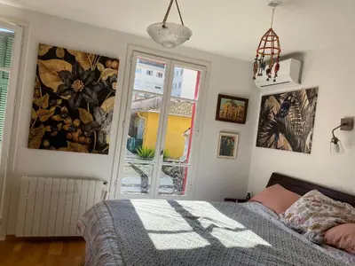 a bedroom with a bed and a window at Maison de ville avec jardin in Nice
