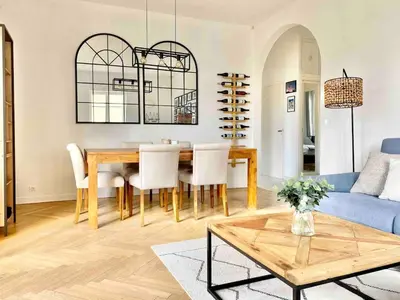 a living room with a table and a blue couch at Nice Sea View 2 bedroom apartment in Nice