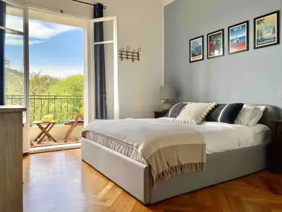 a bedroom with a bed and a large window at Nice Sea View 2 bedroom apartment in Nice