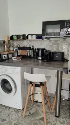 a kitchen with a table and a washing machine at Carré d'Or - Studio lumineux à 5 minutes de la plage in Nice