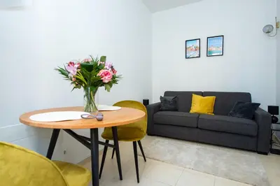 a gray couch with a yellow pillow in a living room at Iconic Central Flat in Nice