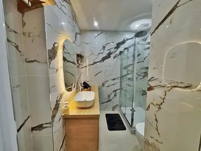 a bathroom with a marble wall with a sink and a shower at Charming apartment in Nice in Nice