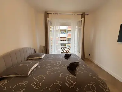 a bedroom with a bed and a large window at Charming apartment in Nice in Nice