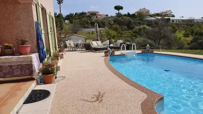 a swimming pool in front of a house at Studio-mezzanine dans villa in Cagnes-sur-Mer