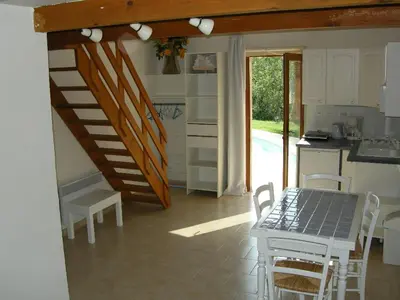 a kitchen with a table and a staircase in a room at Studio-mezzanine dans villa in Cagnes-sur-Mer