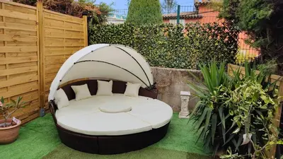 a garden with a bed in the middle of a yard at Nice Absea Belles Terres Studio in Nice