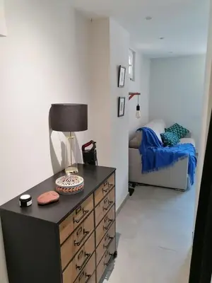 a bedroom with a dresser with a lamp and a bed at Joli studio à Nice in Nice