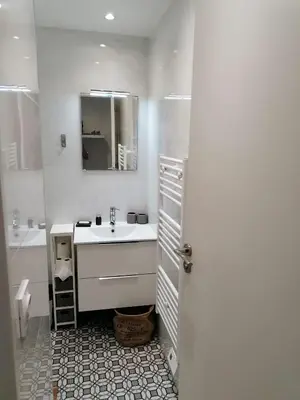 a white bathroom with a sink and a mirror at Joli studio à Nice in Nice