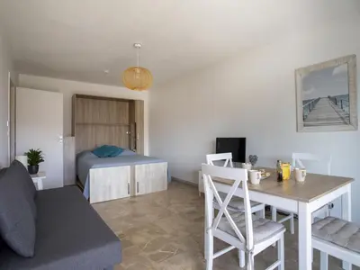 a living room with a bed and a dining room table at Apartment Cagnes Provencal by Interhome in Cagnes-sur-Mer