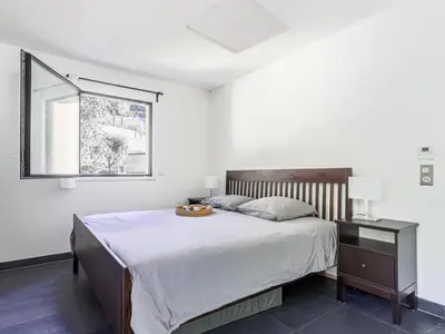 a bedroom with a large bed and a window at Apartment Prestige view by Interhome in Èze