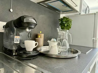a kitchen counter with a coffee maker and cups at Cosy Apartment Vauban in Nice