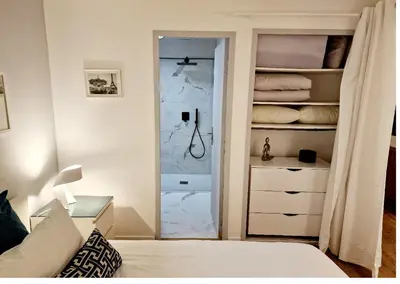 a bedroom with a bed and a closet with a glass door at Magnifique vue mer - Piscine -Tennis in Nice