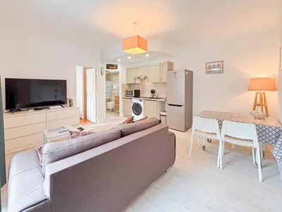 a living room with a couch and a table and a kitchen at Charmant 2P près du Negresco et de la plage - 3pers in Nice