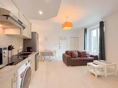a kitchen and a living room with a couch at Charmant 2P près du Negresco et de la plage - 3pers in Nice