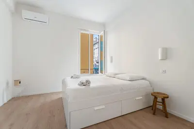 a white bedroom with a bed and a window at Appartement Ostave - Welkeys in Nice