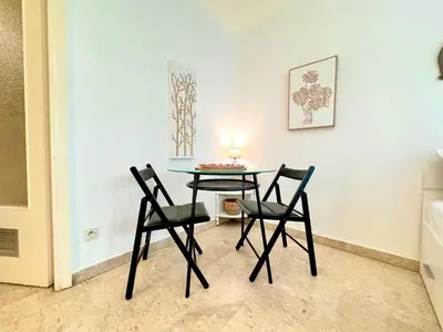 a table and two chairs in a room at A G Cocon Massenet - Grimaldi - Promenade des Angl in Nice