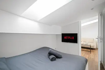 a bedroom with a bed and a sign on the wall at Vieux Nice - Dernier étage climatisé in Nice