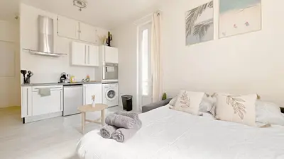 a white bedroom with a bed and a kitchen at La Bella Niçoise in Nice