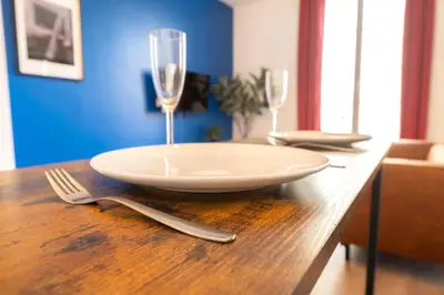 a plate and two wine glasses on a wooden table at Nice Centre - Loft - Balnéo 1 in Nice