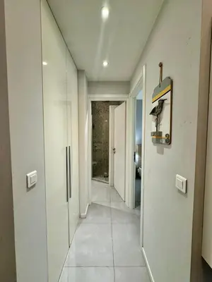 a hallway with white walls and a door with a mirror at Suite Doulce France FSHH in Nice