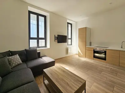 a living room with a couch and a table at Joli studio rénové en centre-ville proche tramway in Nice