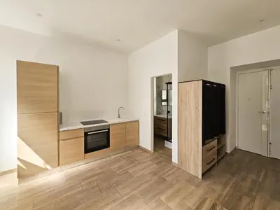 a kitchen with a refrigerator and a television in it at Joli studio rénové en centre-ville proche tramway in Nice