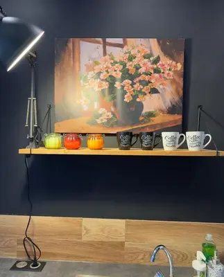 a shelf with a painting of a vase with flowers at Spacious Riviera Studio in Nice