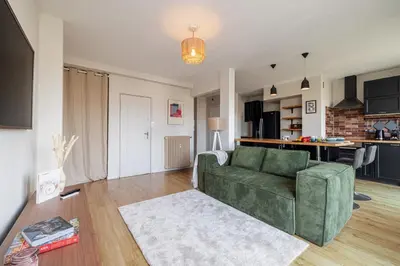 a living room with a green couch and a kitchen at MY CASA - DELFINO - Charming roof terrace apartment w AC in Nice