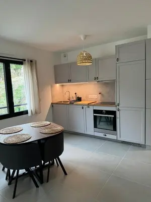 a kitchen with a table and two chairs in it at Appartement entre Monaco et Nice Calme et tout équipé in Èze