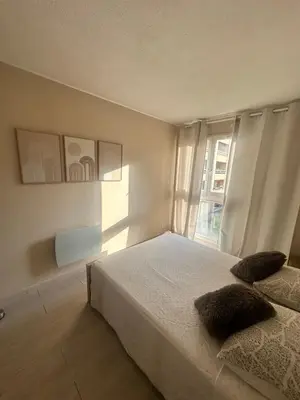 a white bedroom with a bed and a window at Apartment near Beach-Airport Open 24h in Saint-Laurent-du-Var