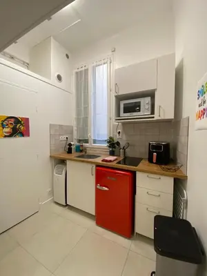 a kitchen with a red refrigerator and a microwave at Studio Garibaldi in Nice