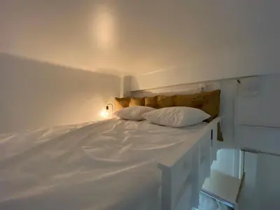 a white bed with two pillows on top of it at Studio Garibaldi in Nice