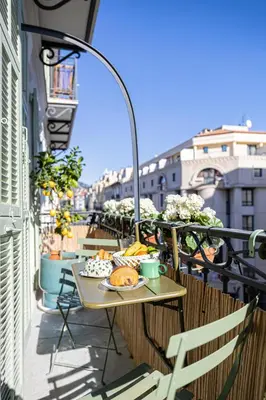 a table with a plate of food on a balcony at NEW! Remodeled & Spacious 4 Bedroom - 3 Bath - Heart of Nice - AC in all rooms - With a large elevator in Nice