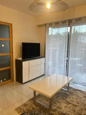 a living room with a tv and a coffee table at 2P cosy à Nice in Nice