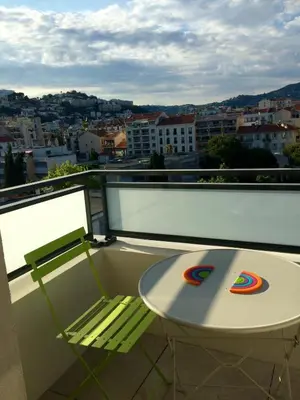 a balcony with a table and a view of a city at Ma place au sud Nice 604 in Nice
