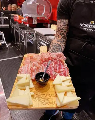 a person standing in a kitchen with a table of cheese at Hotel La Citadelle in Villefranche-sur-Mer