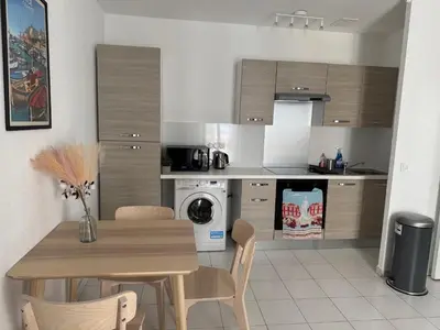a kitchen with a wooden table and a dining room at Bel appartement au calme hyper centre Nice in Nice