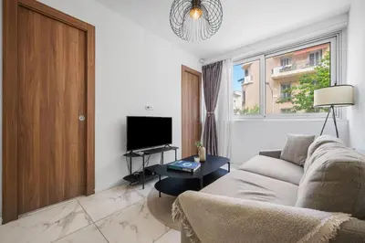 a living room with a couch and a tv at Nice - Mordern Apartment Sea Close in Nice