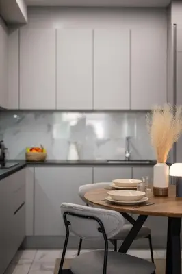 a kitchen with a table and chairs and white cabinets at Nice - Mordern Apartment Sea Close in Nice