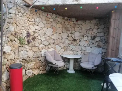 a stone wall with two chairs and a table at Unique havre de paix in Nice