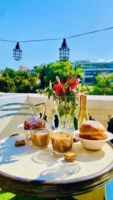 a table with food and a vase of flowers on it at Nice - Little Studio with Sunny Terrace in Nice
