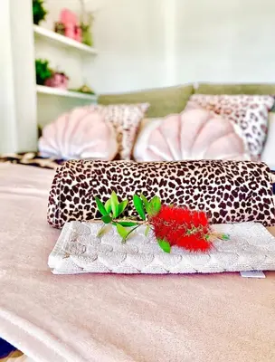 a bed with a pillow with a red flower on it at Nice - Little Studio with Sunny Terrace in Nice