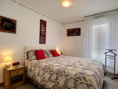 a bedroom with a large bed with red pillows at Nestor&Jeeves - VILLA HARMONIE TERRASSE - Central - Free parking in Nice