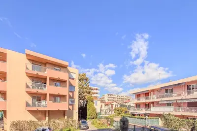 an apartment building with cars parked in front of it at Contemporary 2P Studio Just Steps from the Beach in Cagnes-sur-Mer