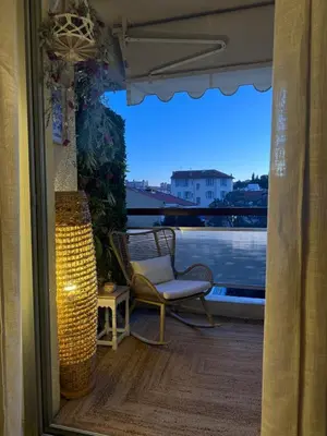 a balcony with a chair and a view of a river at Les Floralies - Beaulieu-sur-Mer in Beaulieu-sur-Mer